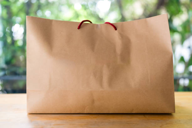 Brown paper shopping bag or Recycled paper kraft shopping bag on wood table