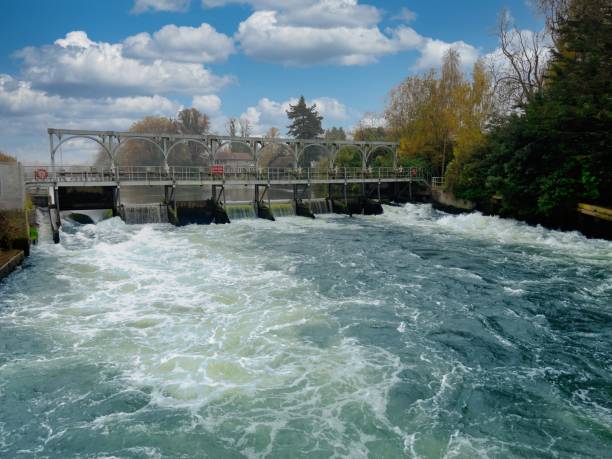 istock Water Flowing Over a Concrete Weir with fish ladder on the river Thames 2184172519
