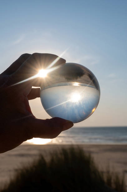 istock Beach and sea reflected in a ball in a human hand 2184172675