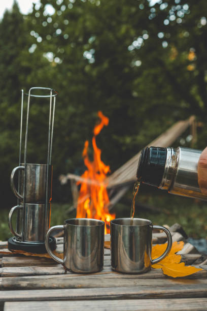 istock Themed trip. The man pours a hot drink into the thermos 2184172751