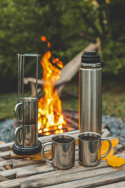 istock Themed trip. The man pours a hot drink into the thermos 2184172757