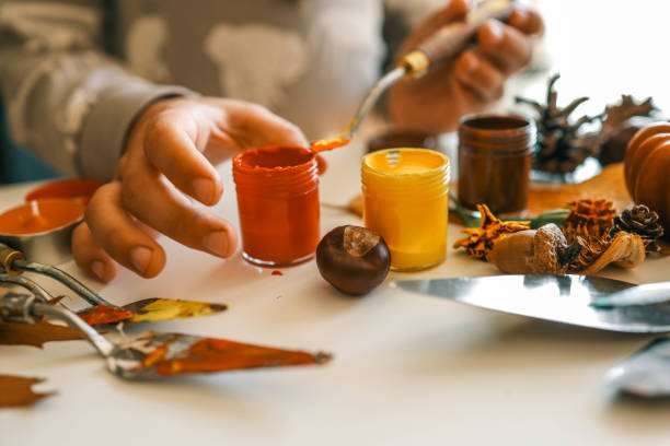 istock Creative autumn art activity with paint and natural materials like pine cones, acorns, and chestnuts, crafting seasonal decorations 2184173035