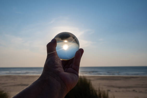 istock Beach and sea reflected in a ball in a human hand 2184173113