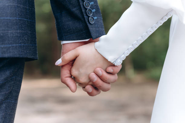istock bride and groom hold hands together 2184173587