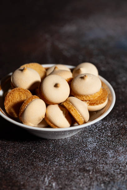 istock plate with amaretti cookies on dark background, vertical top view 2184173972