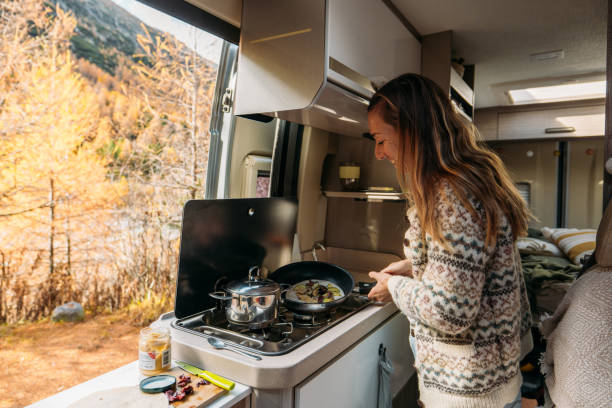 Woman Cooking Inside Cozy Camper Van in Autumn Forest