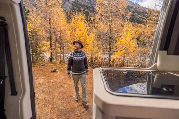 istock Man Enjoying Autumn Scenery Outside Camper Van 2184179285