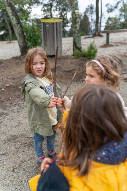 istock Image vertical the friends Playing with Sticks in the Forest 2184179779