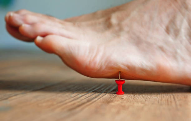 A pin poking into a person's foot -- nerve pain concept