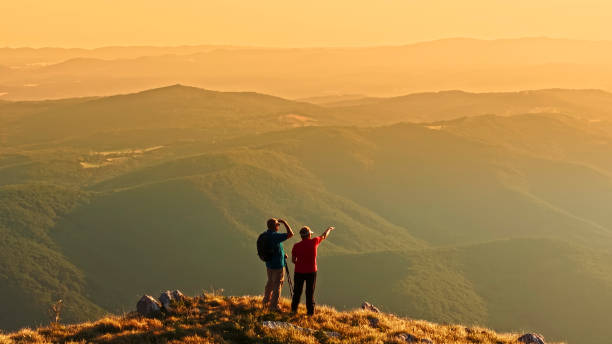 istock Elderly Couple Enjoys Sunset Scenery on Nature Hike 2184183129