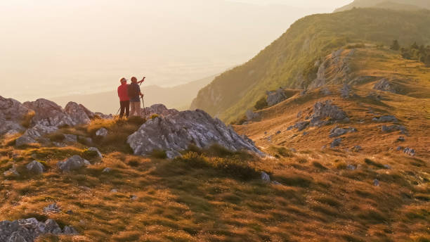 istock Active Elderly Caucasian Couple Watches Sunset on Mountain Hike 2184183153