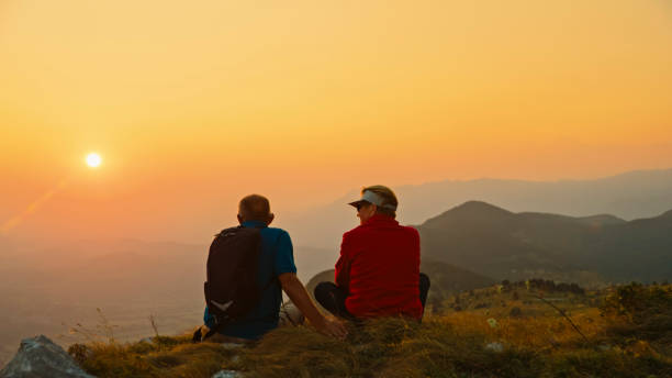 istock Senior Couple Pauses Hiking to Enjoy Sunset View 2184183373