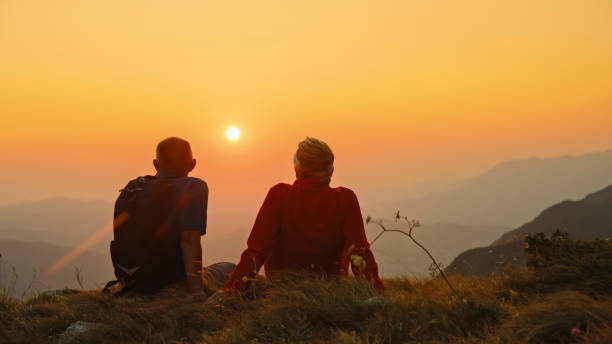 istock Elderly Couple Watches Sunset on Mountain Hike 2184183377