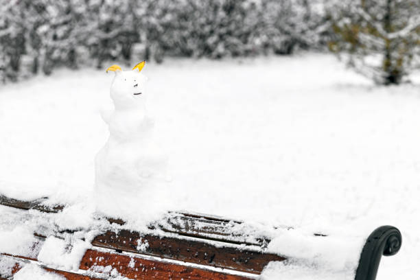 funny snowman made of snow and tree branches in the park. snowman made of tree branches and leaves. High quality photo