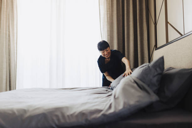 istock Chambermaid changing bed linen on the bed in a hotel room 2184188092