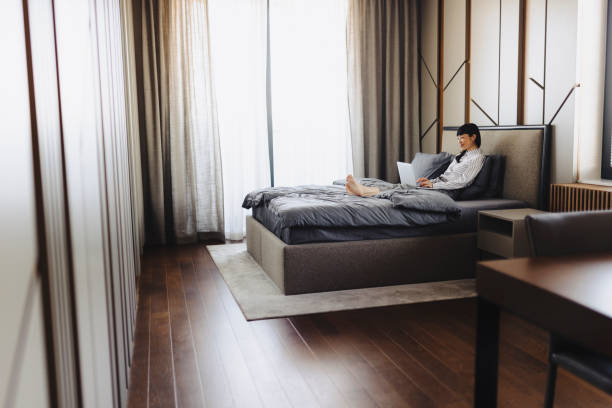 istock Businesswoman using laptop at hotel room 2184188271