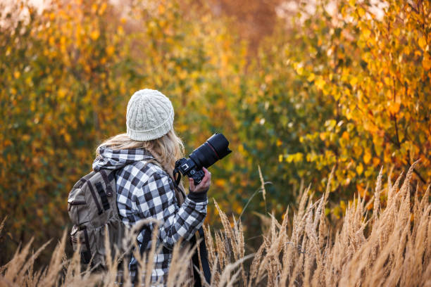 istock Woman photographer with camera exploring autumn nature 2184188318