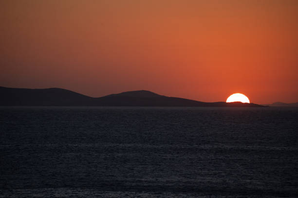 Sunset casts an orange glow over the greek island of Mykonos