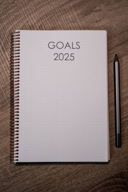 istock New Year Goals 2025: Organized Notebook on Wooden Desk Still Life 2184191297