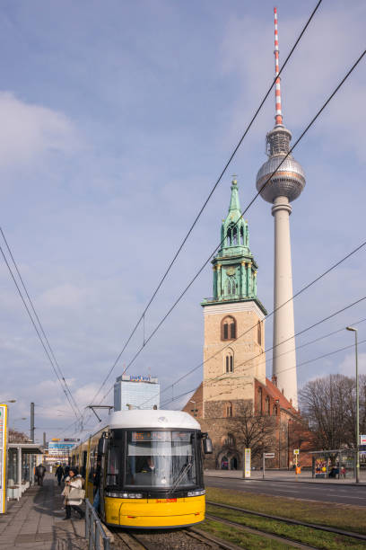Berlin, Germany - February 21, 2014: Tram circulating through the urban center of the city with the television tower and the church of Santa Maria in the background