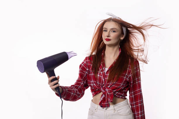 istock Engaging in Innovative and Dynamic Hair Styling with a Blow Dryer in a Creative Studio Setting 2184194223