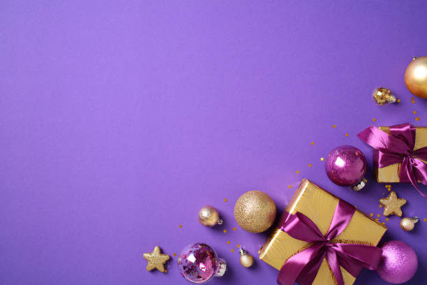 istock Christmas decorations on a vibrant purple background. Flat lay golden gift boxes with violet ribbon bows, gold and purple baubles, stars 2184197774