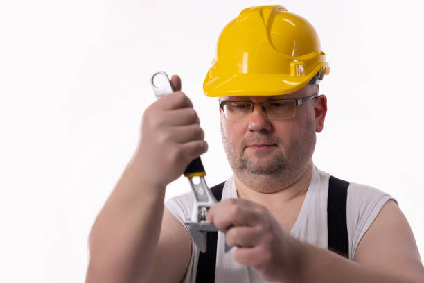 Handyman with yellow hard hat and metal wrench