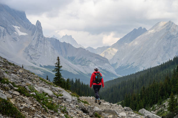 Woman hikes along mountain trail