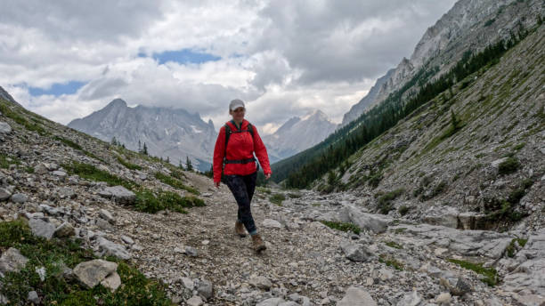 istock Woman hikes along mountain trail 2184198729