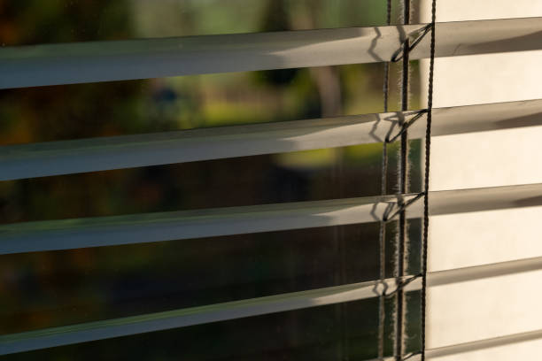istock Sunlight filtering through closed blinds in a tranquil indoor space during the early morning hours 2184199715