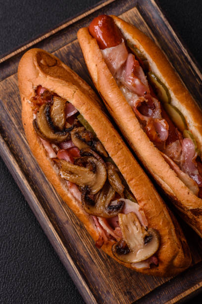 istock Hotdog with grilled sausage with bacon and mushrooms 2184200411