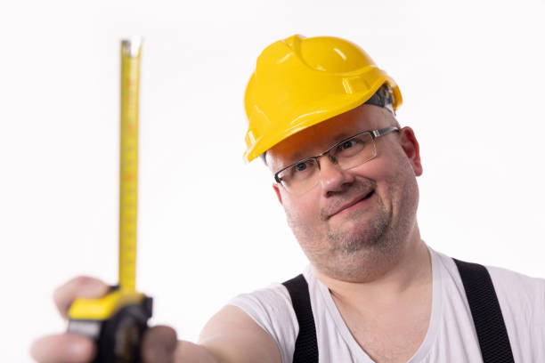 A Construction Worker Using Power Tool in Unfinished Basement of New Home