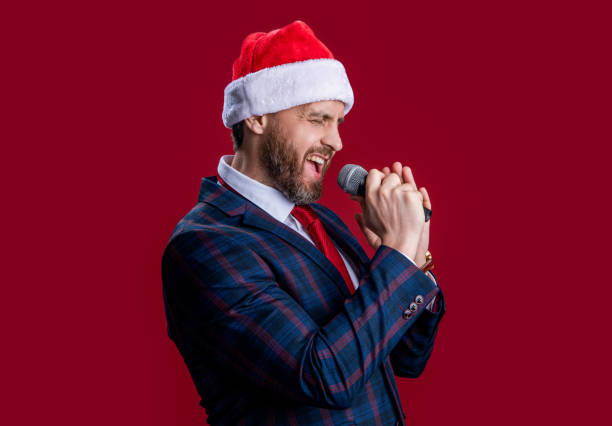 istock cheerful event host man singing with microphone. merry christmas. event host man singing 2184201780