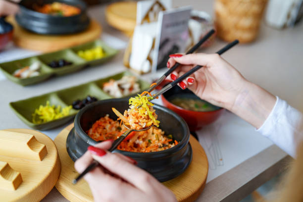 Young woman eating bibimbap at a Korean Restaurant.