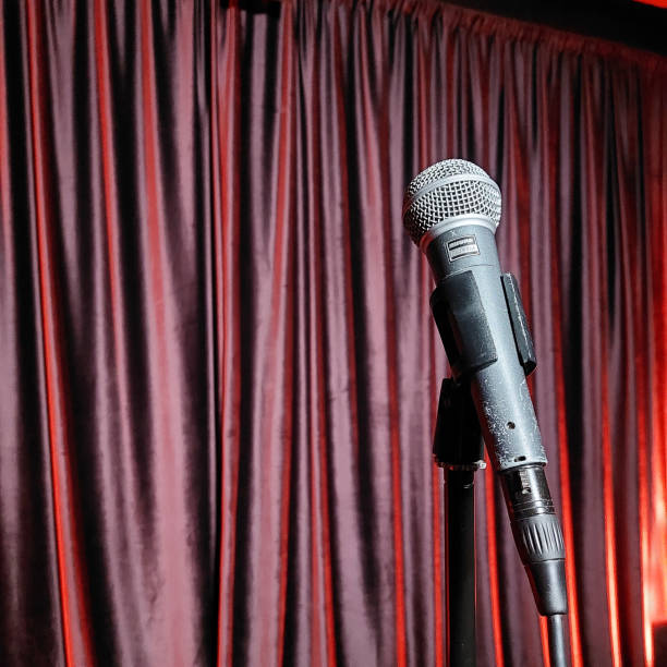 istock Microphone on Stand in Front of Red Curtain on Stage for Performance or Event 2184203958