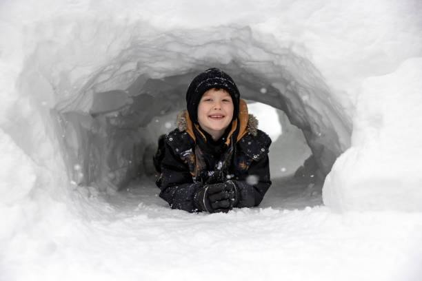 istock Child playing in a snow tunnel during winter 2184206158