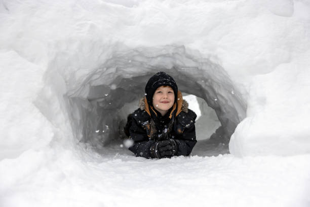 istock Child playing in a snow tunnel during winter 2184206203