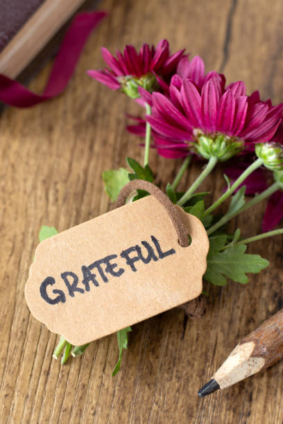 istock Grateful, handwritten word on rustic greeting card with flowers and holy bible book 2184206283