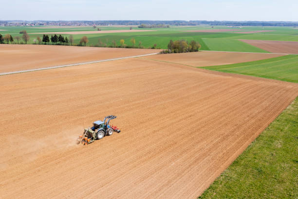 istock Tractor sowing plowed field aerial view 2184207965