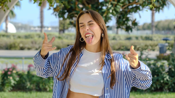 Playful girl with pigtails pointing her finger towards camera on white background