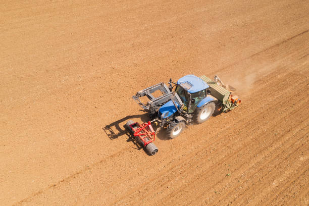 istock Tractor sowing plowed field aerial view 2184208940
