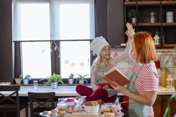 istock Mom and daughter reading recipes in the kitchen 2184209361