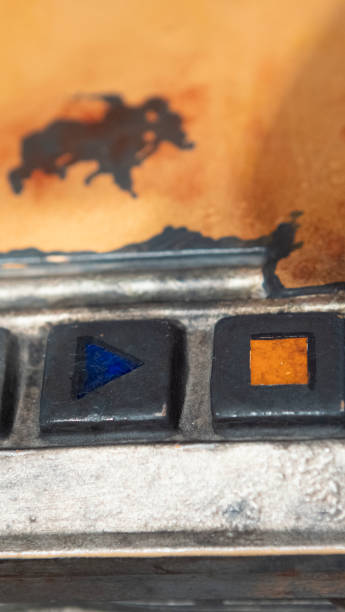 Play and stop buttons on a worn out old radio cassette player.