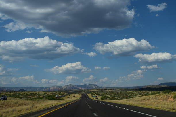 A snap of a typical USA highway going straight ahead in the distance. With an amazing view on the mountains of Arizona.