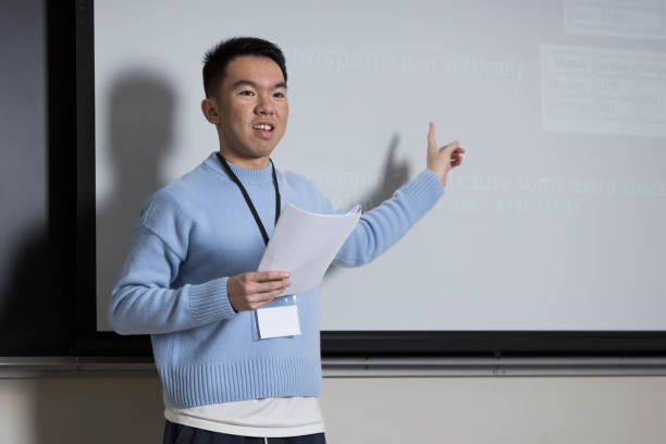 istock A man in a blue sweater is presenting in front of a whiteboard 2184217209