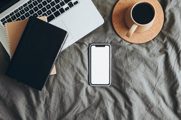 istock Smart mobile phone with blank mockup screen on bed, studying or work concept. 2184217333