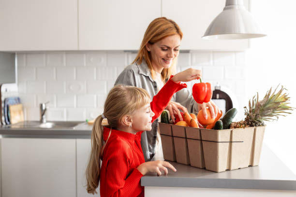 istock Mother and daughter unpacking groceries 2184218557