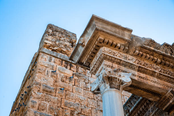A stunning view of Hadrian's Gate, a well-preserved Roman triumphal arch in Antalya, Turkey. Built in honor of the Roman Emperor Hadrian, this historical monument showcases exquisite ancient architecture, with intricate carvings and columns that reflect the grandeur of the Roman Empire. The gate remains a symbol of Antalya's rich cultural heritage and its strategic significance during Roman rule. This captivating image is perfect for travel advertisements, promotions highlighting Turkey’s historic landmarks, or architectural showcases. Ideal for campaigns focusing on cultural tourism, heritage, and ancient architecture.