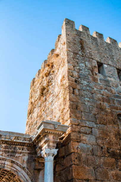 A stunning view of Hadrian's Gate, a well-preserved Roman triumphal arch in Antalya, Turkey. Built in honor of the Roman Emperor Hadrian, this historical monument showcases exquisite ancient architecture, with intricate carvings and columns that reflect the grandeur of the Roman Empire. The gate remains a symbol of Antalya's rich cultural heritage and its strategic significance during Roman rule. This captivating image is perfect for travel advertisements, promotions highlighting Turkey’s historic landmarks, or architectural showcases. Ideal for campaigns focusing on cultural tourism, heritage, and ancient architecture.