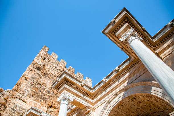 A stunning view of Hadrian's Gate, a well-preserved Roman triumphal arch in Antalya, Turkey. Built in honor of the Roman Emperor Hadrian, this historical monument showcases exquisite ancient architecture, with intricate carvings and columns that reflect the grandeur of the Roman Empire. The gate remains a symbol of Antalya's rich cultural heritage and its strategic significance during Roman rule. This captivating image is perfect for travel advertisements, promotions highlighting Turkey’s historic landmarks, or architectural showcases. Ideal for campaigns focusing on cultural tourism, heritage, and ancient architecture.